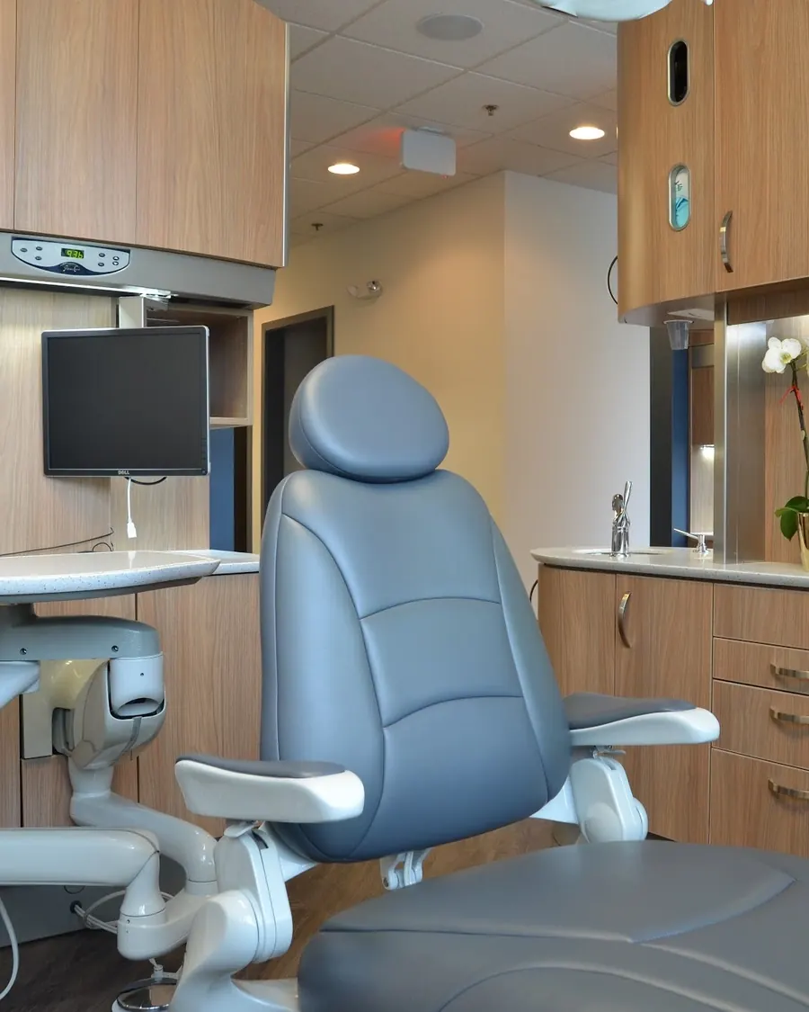 A treatment room at Severn River Dental, with its chair, monitor and wood cabinetry.